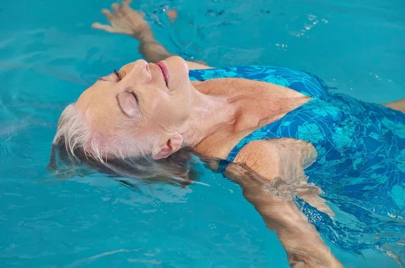 Older woman swimming in pool